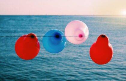 4 balloons on a sting near the ocean