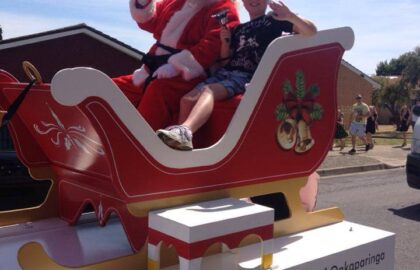 Santa with child at Onkaparinga Christies Beach real estate agency Christmas pageant