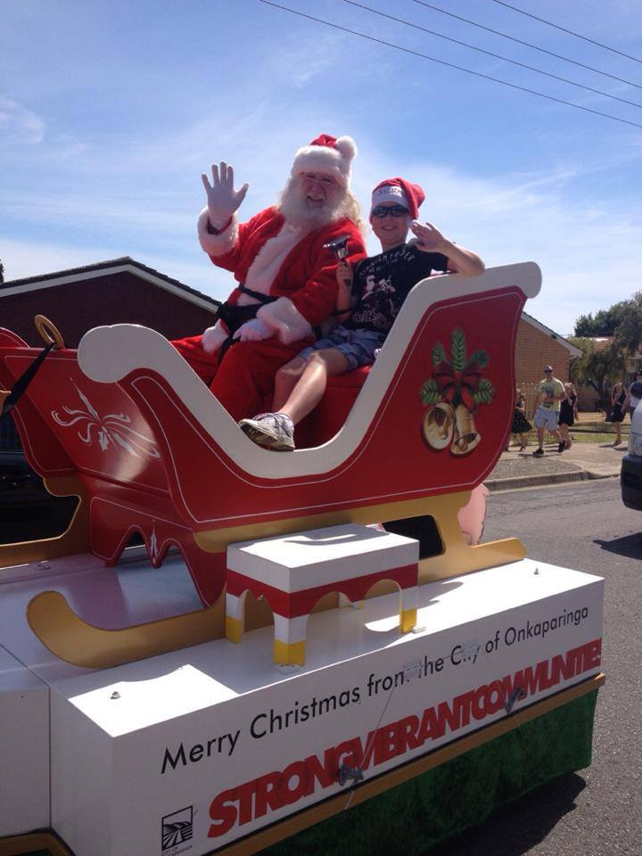 Santa with child at Onkaparinga Christies Beach real estate agency Christmas pageant